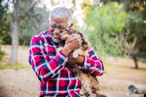 Older man hugging a dog to relieve senior stress