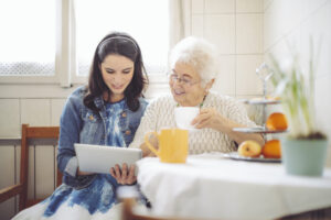 Family caregiver talking with happy senior woman