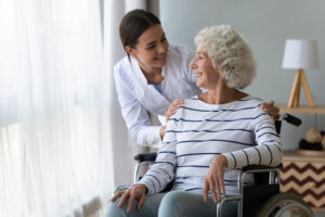 Caregiver embracing senior woman in wheelchair