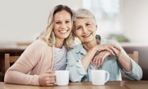 Family caregiver and senior woman smiling together