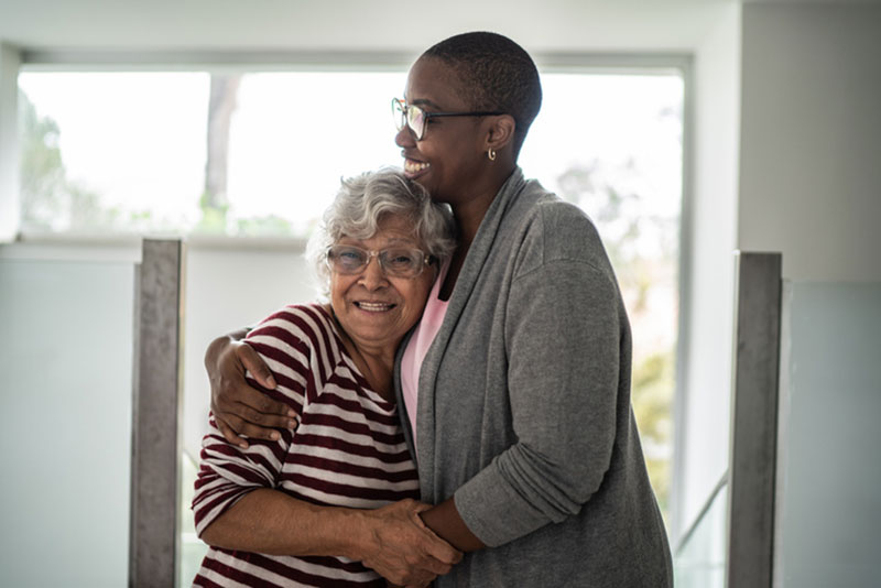 A woman embraces her aging mother after using tips for anxiety management in older loved ones.